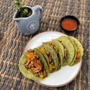 orden de tacos de guiso con verduras salteadas, tortillas de nopal y salsa roja